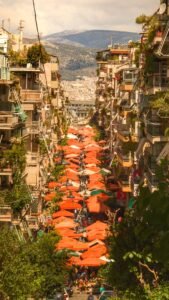 Rows of orange awnings running down Kallidromiou Street in Exarchia on market day