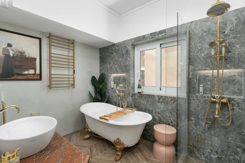 The main bathroom, with a white clawfoot bath and a basin set against green-veined marble.
