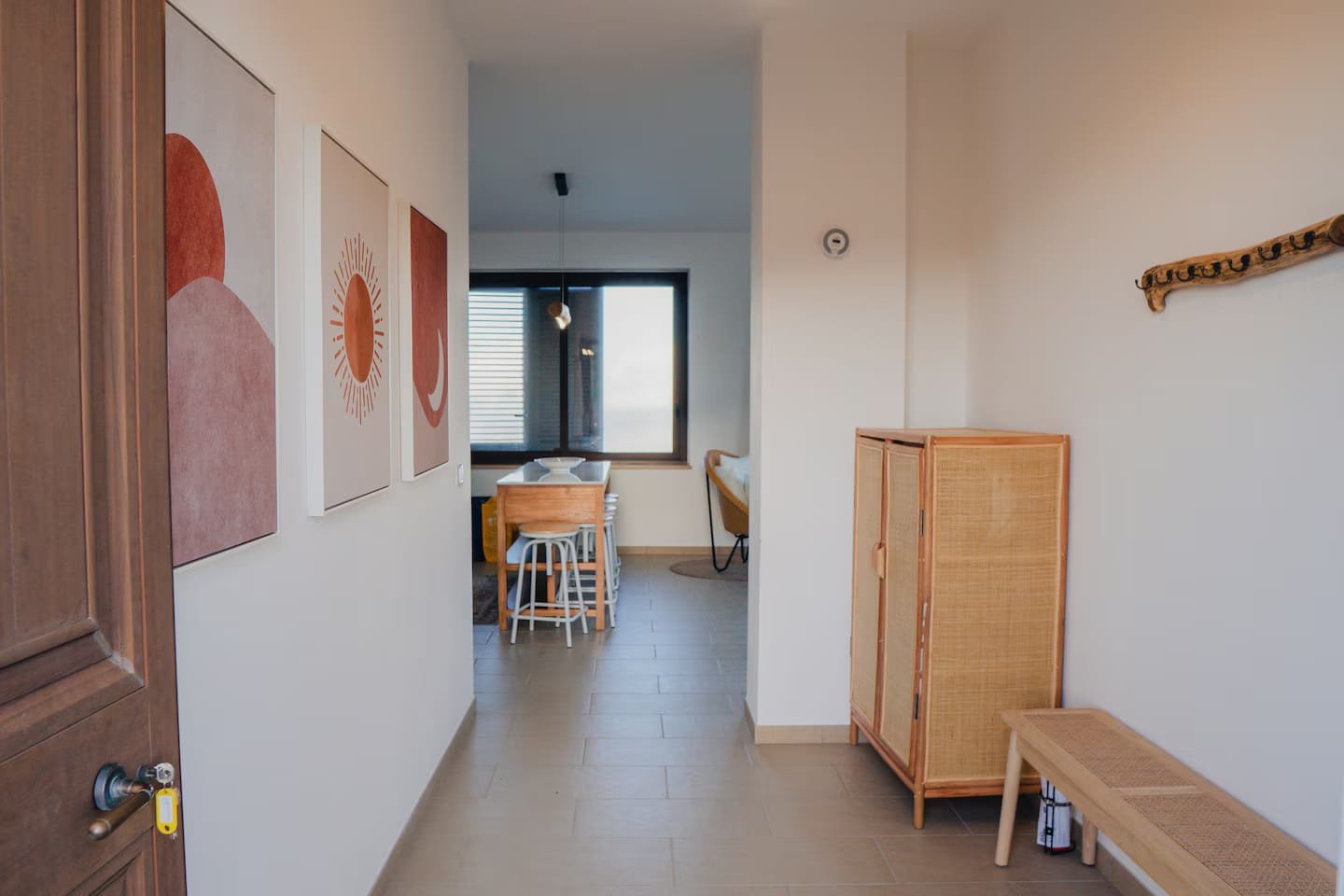 The apartment’s long hallway, hung with framed prints and leading through to the dining area.