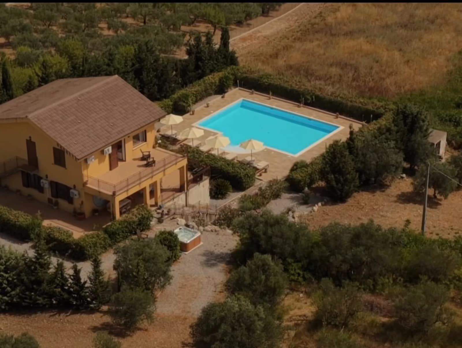 Aerial footage circling Two Brothers Villa in Sicily, its pool and olive terraces below.